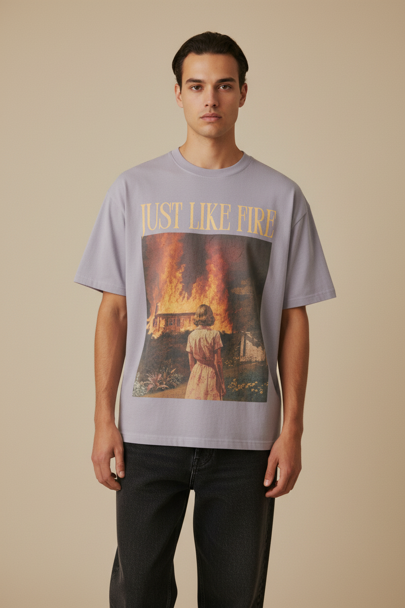 Gray t-shirt with a graphic design of a person watching a house burn and 'Just Like Fire' text.