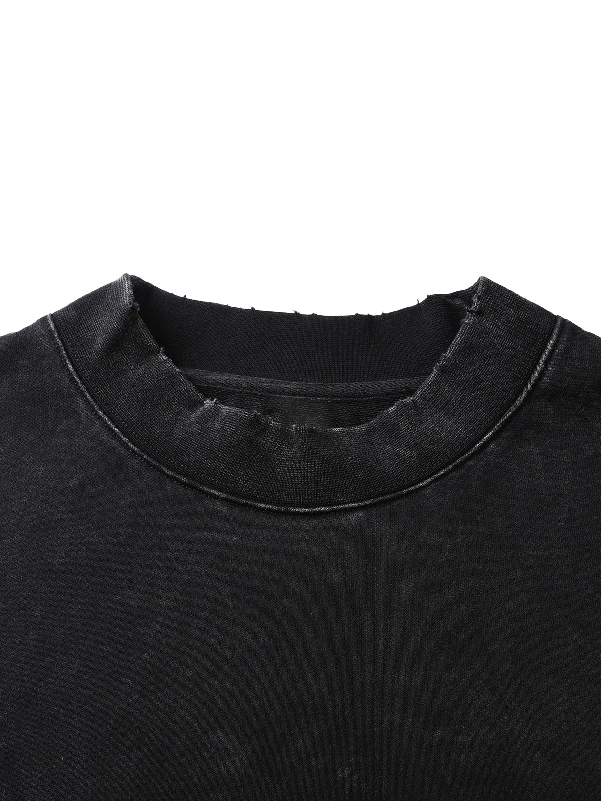 Close-up of a black garment with a textured collar on a white background