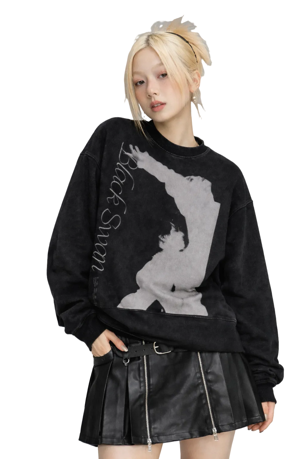 Person wearing a black sweater with graphic design and a leather skirt on a gray background